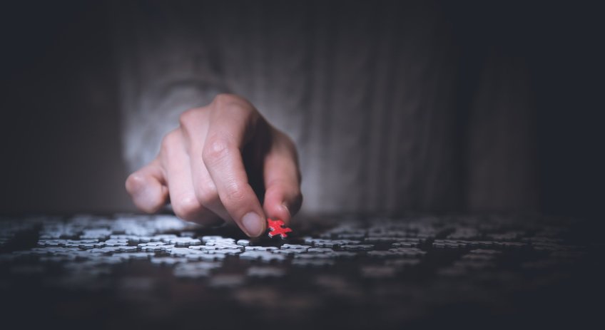 Polizeiliche Prognoseinstrumente Hand mit rotem Puzzleteil