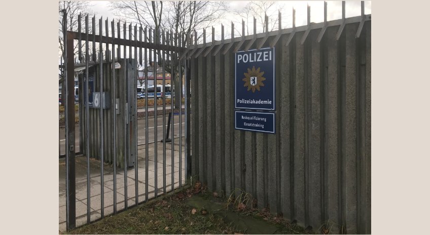 Police academy entrance gate with sign.