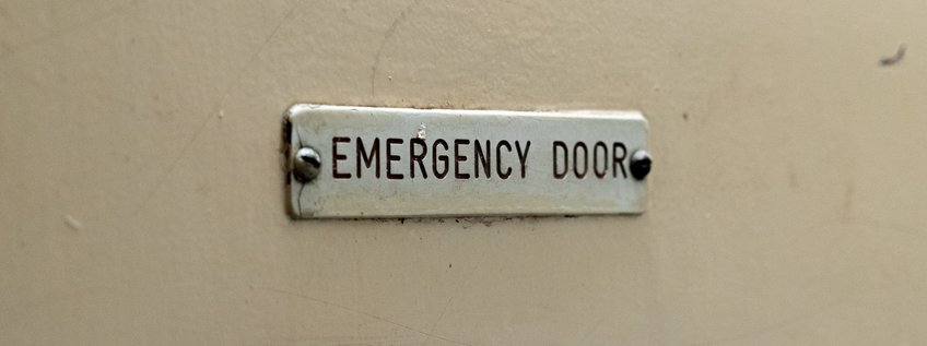 Ausnahmeregelungen und andauernde Ausnahmezustände nach der EMRK Schild mit Aufschrift "Emergency Door"