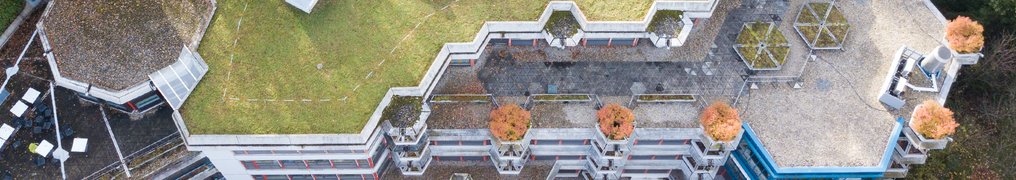 Luftaufnahme des MPI-CSL, begrüntes Dach, Pflanzkästen mit Bäumen, angrenzende Dachterrasse.